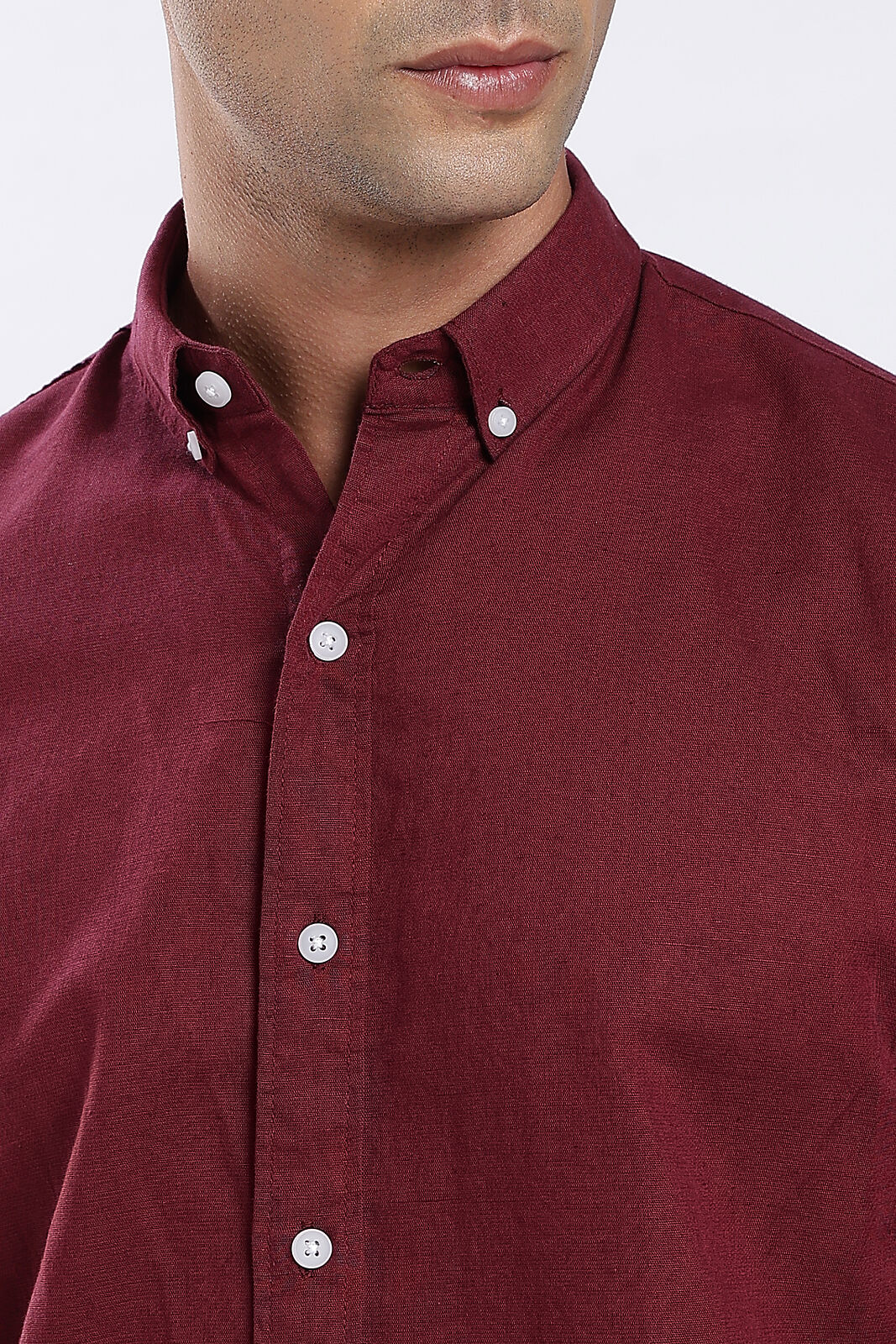 Close-up of a maroon linen shirt collar and buttons