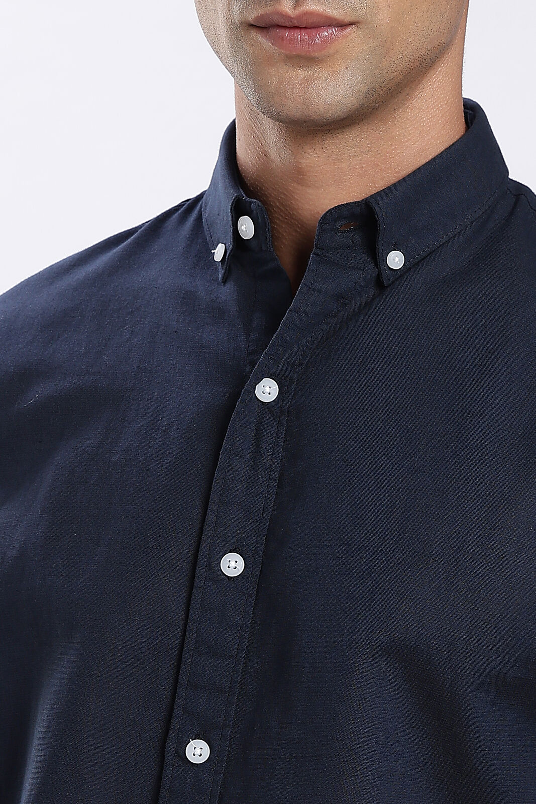 Close-up of a navy linen shirt collar and buttons